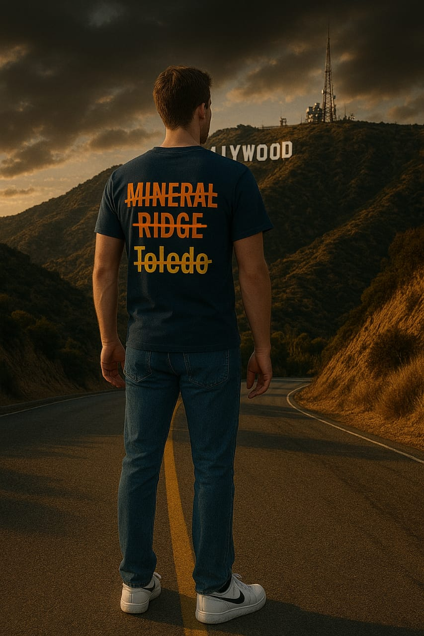 John Kundly walking a California road, his back to the camera, a t-shirt crossing out Mineral Ridge, Ridge, and Toledo with the Hollywood sign in the distance